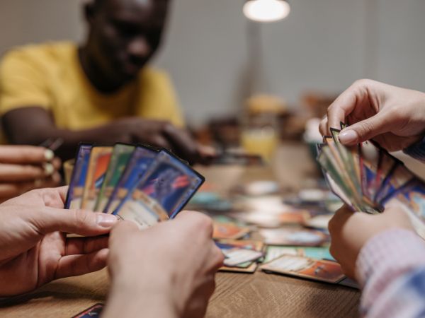 close up of hands of two people holding cards