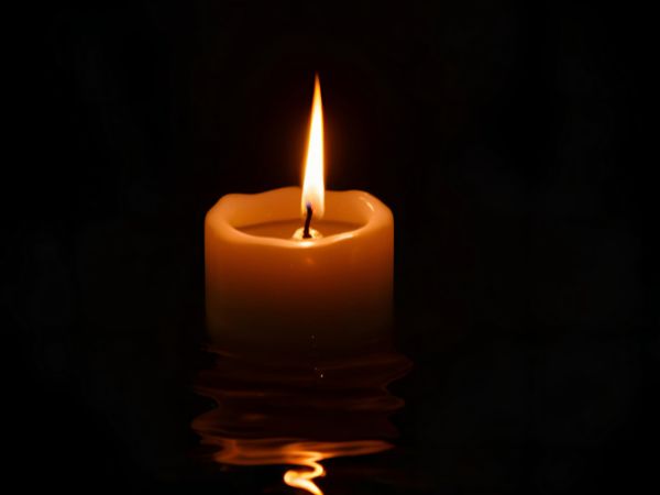 single candle light on a black background