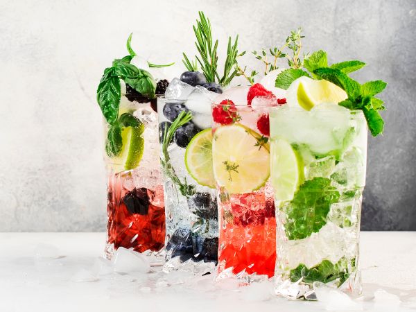 four glases with fruit and clear liquid