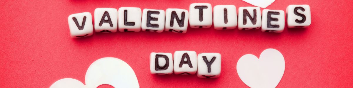 Red background with white beads that spell Valentines Day